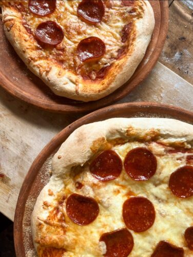 two pepperoni pizza cooked on Miriam's Eathen Cookware Clay Griddles