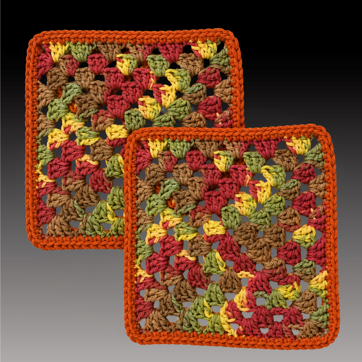 Two hand-crocheted cotton clay pot coasters in a granny-square pattern, worked in autumn tones of rust, red, gold, olive, and brown with a solid terracotta border.